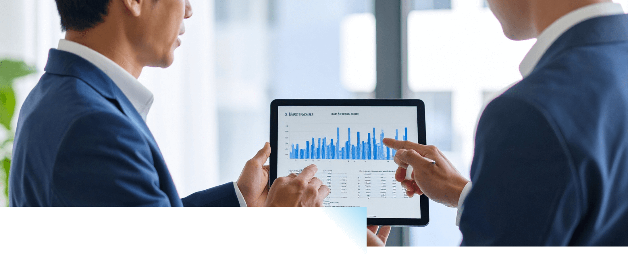 タブレットを見ながらミーティングするスーツの男性たち