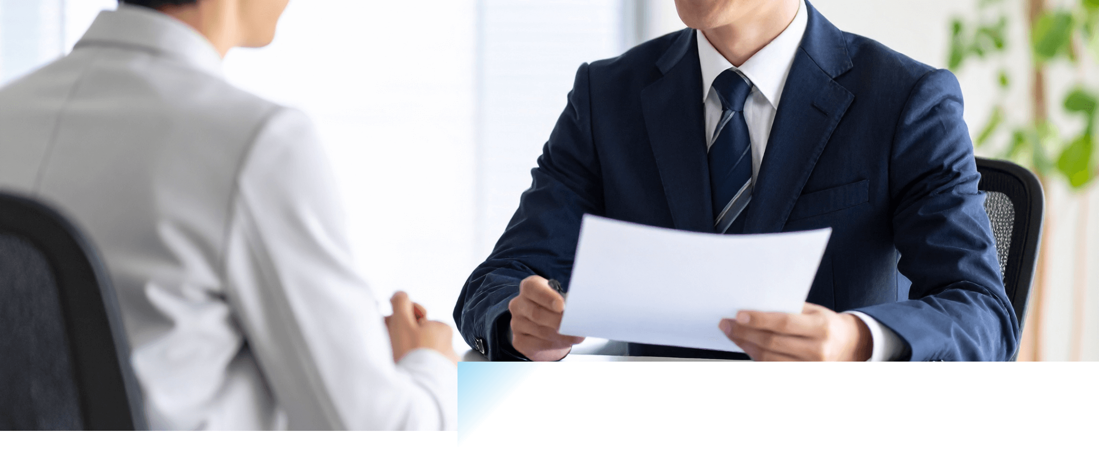 書類を片手にミーティングするスーツの男性たち