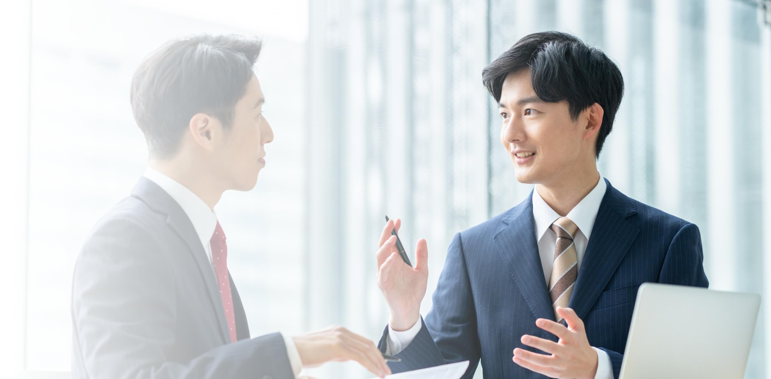 スーツの男性が会話する様子の画像